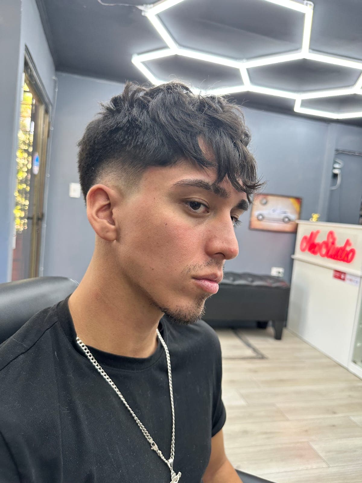 Cliente de Neo con corte texturizado, en el estudio con sus luces hexagonales